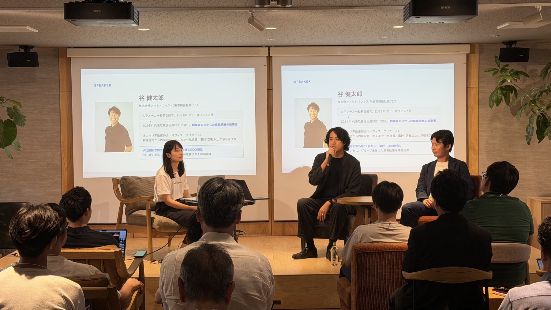 パネルディスカッションの登壇者。スクリーンに代表・谷健太郎のプロフィールが映っている